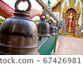 Many bells in the temple allow people to strike to make a loud noise. 67426981