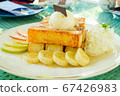Toast and ice cream are placed on top, paired with bananas and apples. 67426983