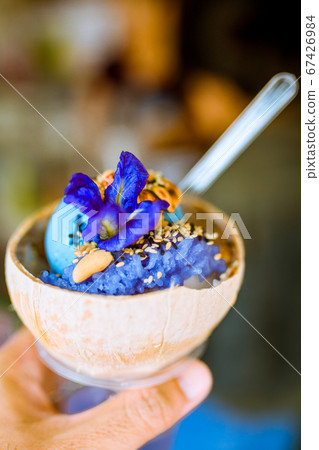 This is a kind of dessert that has ice cream and sticky rice, with flowers on top. This is a kind of dessert that has ice cream and sticky rice, with flowers on top. 67426984