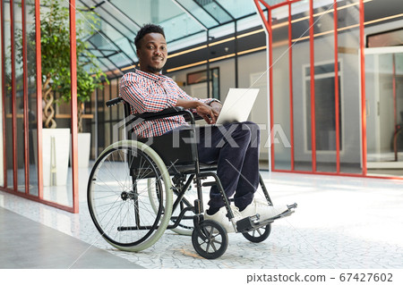 Disabled man working on laptop Disabled man working on laptop 67427602