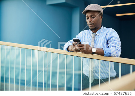 Man using mobile phone at office Man using mobile phone at office 67427635