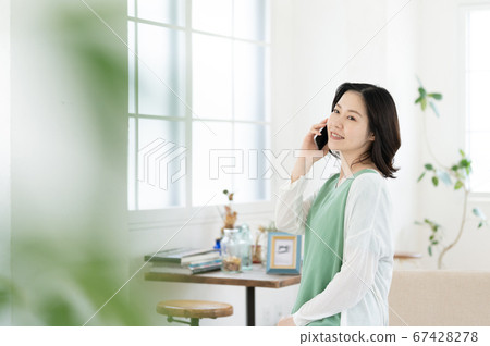 A middle woman who calls on a smartphone [Living] 67428278