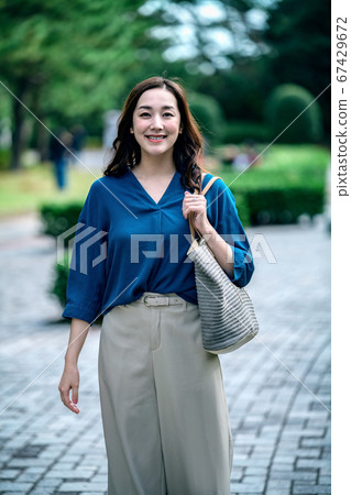 年輕休閒家庭主婦在公園散步的肖像 年輕休閒家庭主婦在公園散步的肖像 67429672