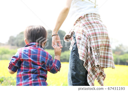 Parent and child holding hands during a walk 67431193