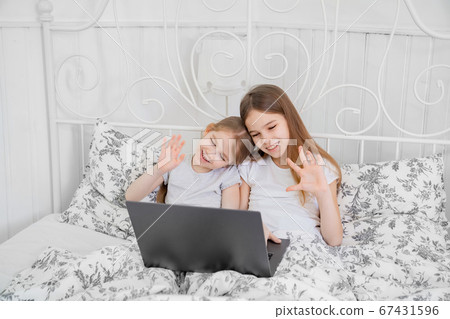 two sisters talk via video connection on computer two sisters talk via video connection on computer 67431596