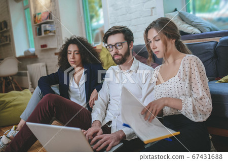 Boyfriend with laptop, girl with folders nearby, girlfriend behind Boyfriend with laptop, girl with folders nearby, girlfriend behind 67431688