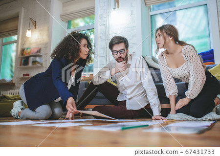 Thoughtful serious two girls and guy with documents. Thoughtful serious two girls and guy with documents. 67431733