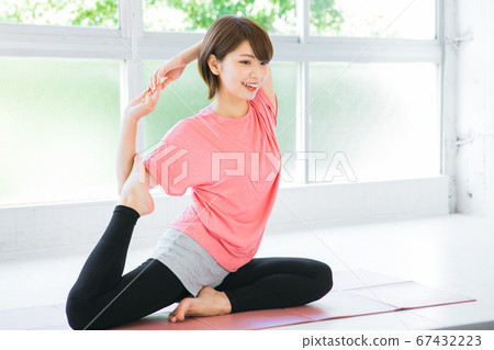 Young woman doing yoga in the room Young woman doing yoga in the room 67432223