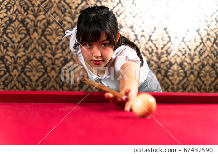 Young woman enjoying billiards 67432590