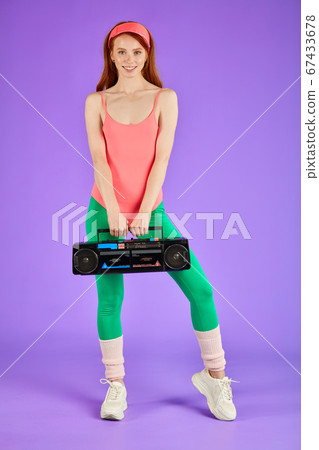 view of slim girl waiting for dance classes, holding portable audio player view of slim girl waiting for dance classes, holding portable audio player 67433678