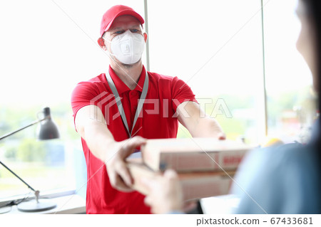 Courier in medical mask delivering pizza closeup Courier in medical mask delivering pizza closeup 67433681