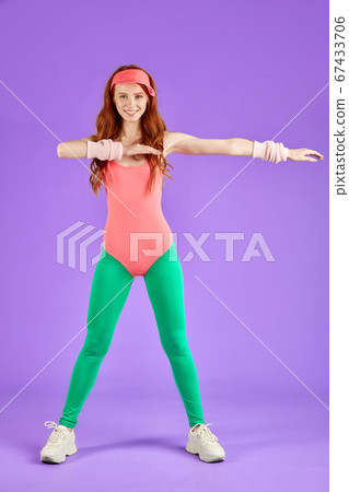 red-headed girl wears aerobics clothes in 80s style looks in camera red-headed girl wears aerobics clothes in 80s style looks in camera 67433706