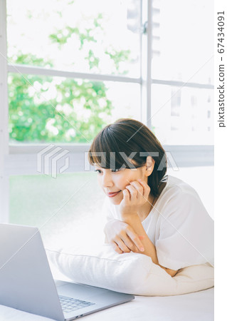 躺下並使用計算機的女性(*請不要在諸如婚姻活動和約會社之類的網站和應用上使用計算機) 躺下並使用計算機的女性(*請不要在諸如婚姻活動和約會社之類的網站和應用上使用計算機) 67434091