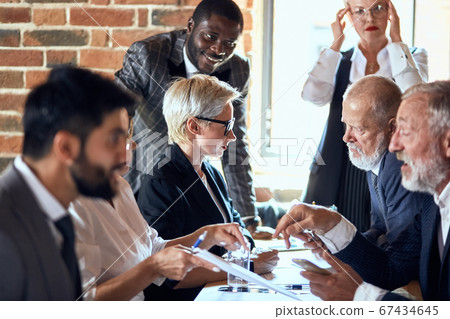 Business people at the negotiating table in the office Business people at the negotiating table in the office 67434645