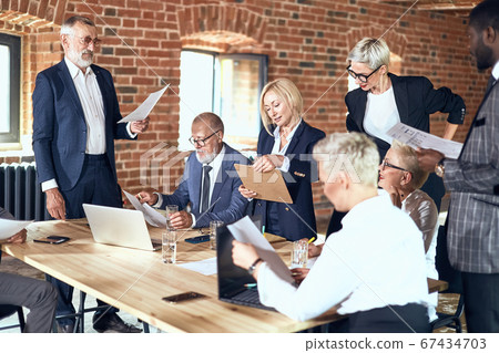 Group of business people brainstorming together in meeting room Group of business people brainstorming together in meeting room 67434703