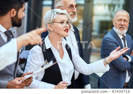 Group of businessmen walking down the street Group of businessmen walking down the street 67434718