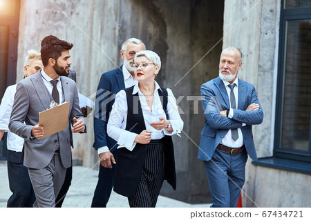 Group of businessmen walking down the street 67434721