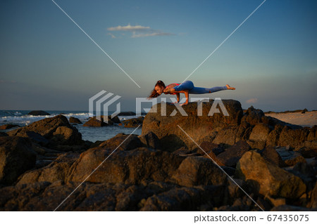Woman is practicing bakasana Woman is practicing bakasana 67435075
