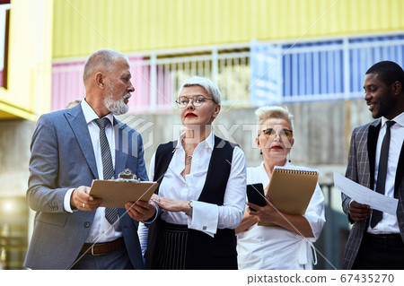 Group of businessmen walking down the street 67435270