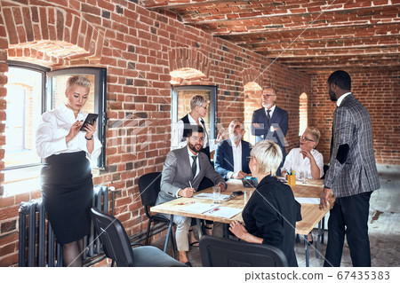 Group of business people brainstorming together in meeting room Group of business people brainstorming together in meeting room 67435383