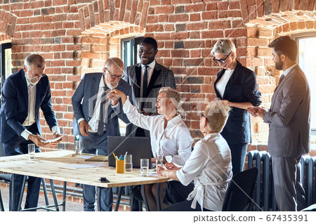 Group of business people brainstorming together in meeting room Group of business people brainstorming together in meeting room 67435391