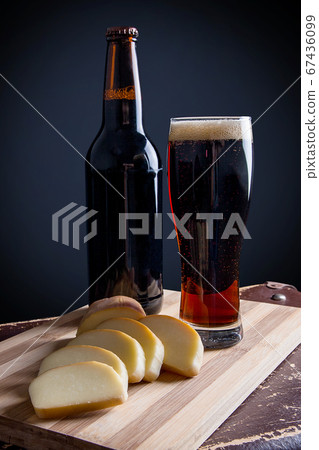 Glass and Bottle of dark beer with smoked cheese Glass and Bottle of dark beer with smoked cheese 67436099