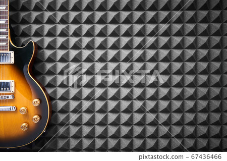 Electric guitar on acoustic foam panel background Electric guitar on acoustic foam panel background 67436466