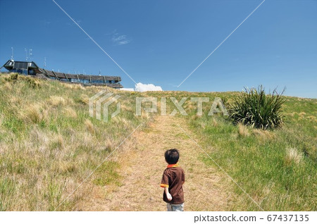 Young asian boy walking toward The Summit Gondola Station in Mt Cavendish, New Zealand Young asian boy walking toward The Summit Gondola Station in Mt Cavendish, New Zealand 67437135