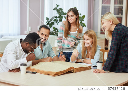 Diverse multiracial students spending leisure time in library with big old book 67437426