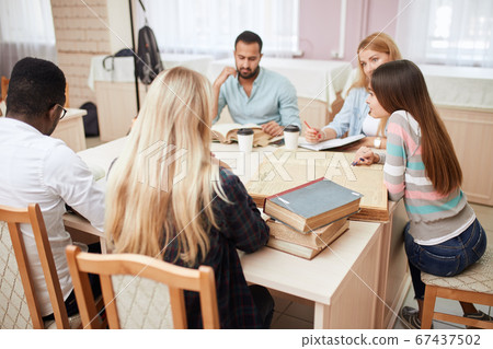 Group of multiracial people studying with books in college library. Group of multiracial people studying with books in college library. 67437502
