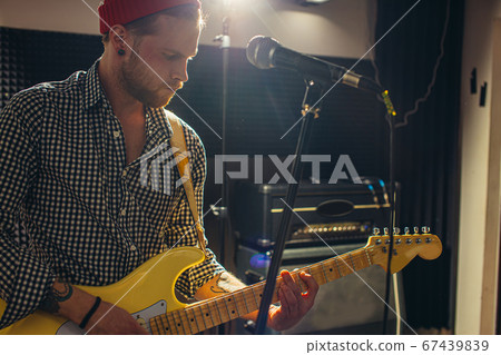 serious caucasian guitarist play electric guitar 67439839