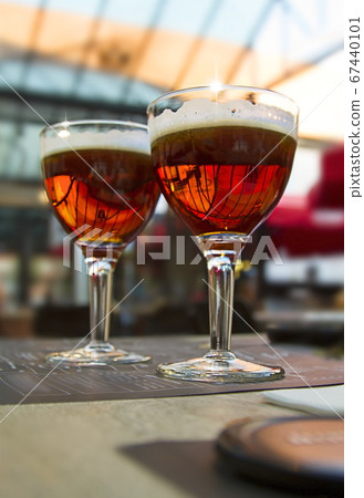 Blur light background with two dark beer glasses on cafe table Blur light background with two dark beer glasses on cafe table 67440101