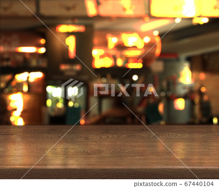Blur bokeh background with empty wooden table top in night cafe Blur bokeh background with empty wooden table top in night cafe 67440104