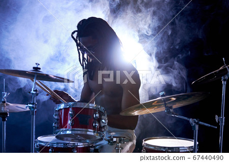 silhouette of drummer man sit hitting on drums isolated over smoke silhouette of drummer man sit hitting on drums isolated over smoke 67440490