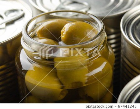 Canned green olives in just opened glass mason 67441243
