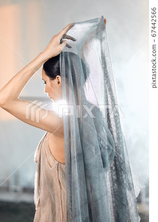 beautiful ballerina wearing cape on head in stage grey loose transparent dress 67442566