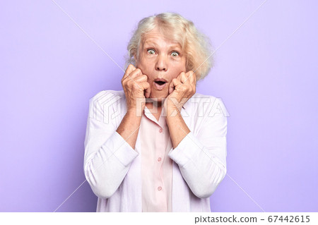 old female doctor with fists on her cheek expresses astonishment old female doctor with fists on her cheek expresses astonishment 67442615