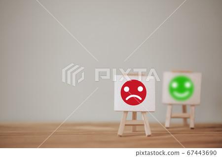 Satisfaction survey concept: Sign stand a sad face and a smiley face on wood table. depicts the best excellent business services rating customer experience.; 67443690