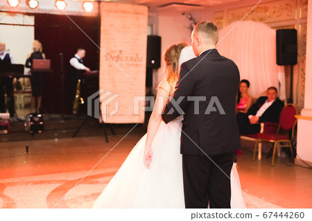 Beautiful caucasian wedding couple just married and dancing their first dance Beautiful caucasian wedding couple just married and dancing their first dance 67444260