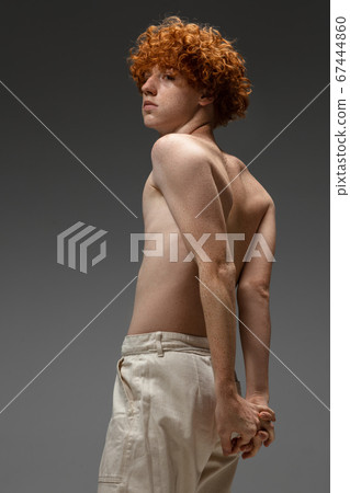 Portrait of beautiful redhead man isolated on grey studio background. Concept of beauty, skin care, fashion and style Portrait of beautiful redhead man isolated on grey studio background. Concept of beauty, skin care, fashion and style 67444860