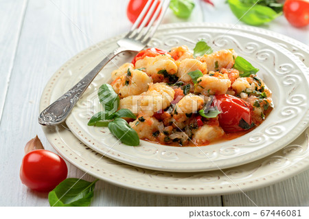 Traditional potato gnocchi with tomato sauce. 67446081