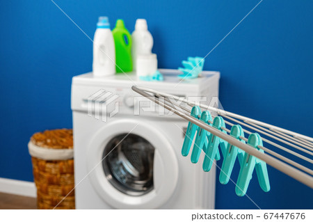 Laundry room interior with washing machine and clothes dryer near wall Laundry room interior with washing machine and clothes dryer near wall 67447676