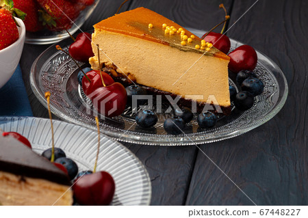 Piece of souffle cake with caramel top served with berries 67448227