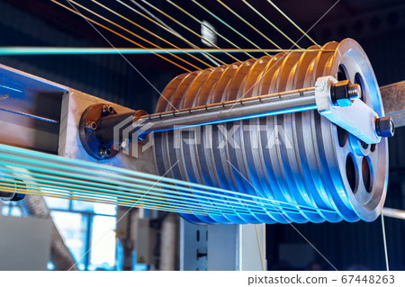 Inside a modern plant producing power electric cables and optical fibers. .Cable manufacturing machine part. 67448263