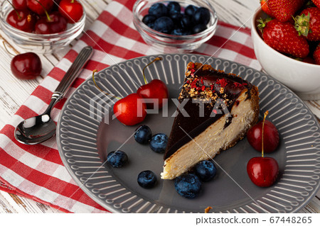 Vanilla cheesecake with chocolate top and berries 67448265