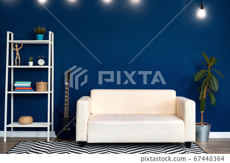 Modern living room interior with white sofa against blue wall 67448364