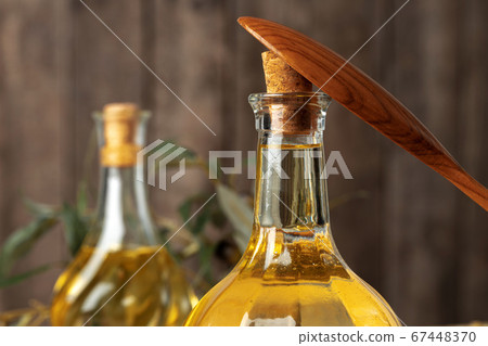 Olive oil bottle on wooden table, close up. Olive oil bottle on wooden table, close up. 67448370