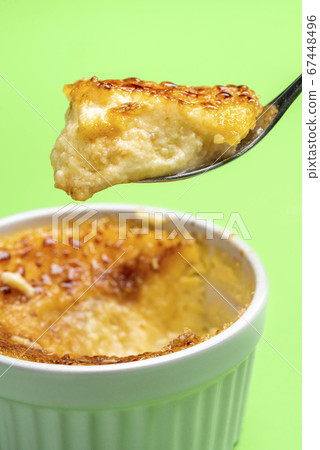 Creme brulee in a spoon close-up. Eating creme Creme brulee in a spoon close-up. Eating creme 67448496