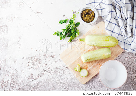 Fresh zucchini on a wooden board with a knife Fresh zucchini on a wooden board with a knife 67448933