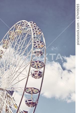 Retro toned picture of a Ferris wheel on a sunny day 67449093